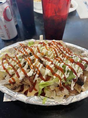 Bbq nachos with pulled pork, bbq sauce, sour cream, and lettuce