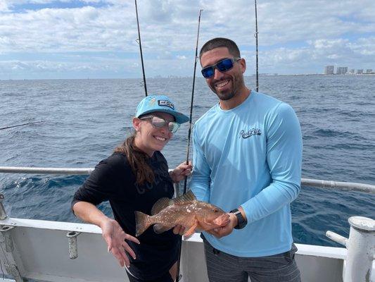 She caught the grouper but was too scared to hold it!