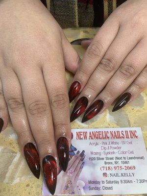 Cat eye nail design with black base and dark blood red top Shape: Long narrow almond (tips dulled to not be sharp like stiletto cat claws)