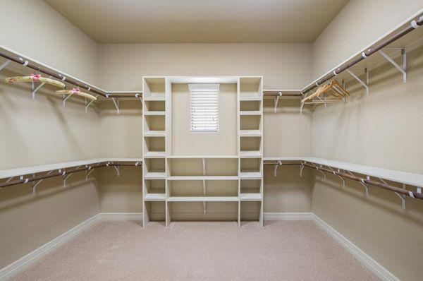 Huge walk-in closet with tons of hanging and storage space. Ladies, lots of room for shoes!