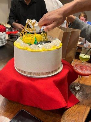 A birthday cake; yellow pineapple cake with white frosting, diamond band and yellow flowers. $70