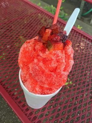 A picadilly snow cone featuring strawberry syrup, pickle chunks and Kool-Aid.