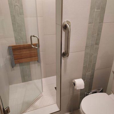 Hall bath showing matching decorative tile in and outside the shower and outside grab bar. There's an inside grab bar too