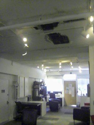 The dining / office room with a broken ceiling right above the dining table. It's been like this for a few months. Only 3 desks for work.