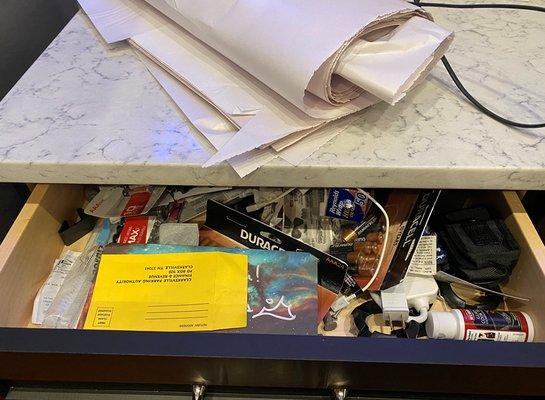 kitchen drawer, not moved, packing paper left on site - cords to appliances remain at old location.