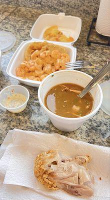 A piece of the fried chicken, gumbo, fried green tomatoes in the back.