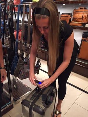 SuperSalesAssociate Racquel demonstrating use of TUMI luggage scale