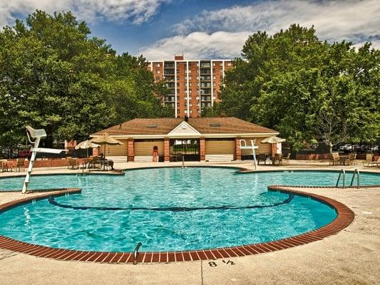 Large swimming pool with locker rooms and plenty of seating and lounge chairs