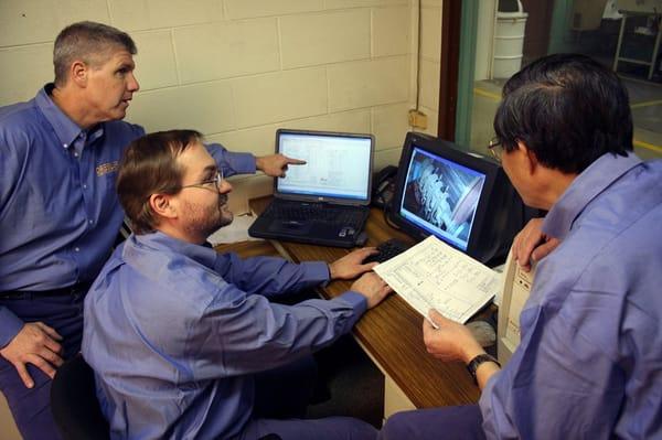 Reliability Field Service technicians discuss a customer's motor program.