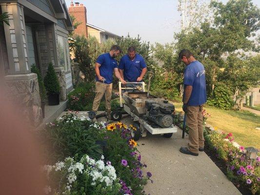 Lift Up crew leveling a sunken and uneven sidewalk pad.