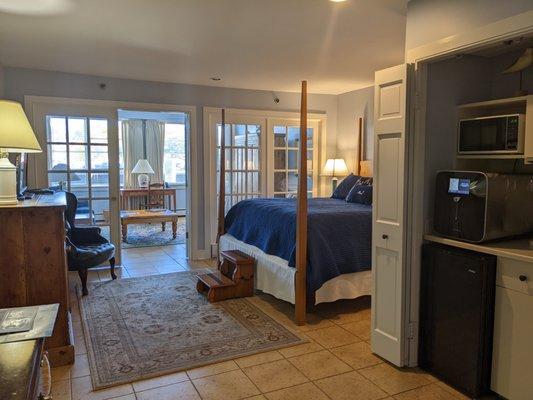 Looking into the bedroom and living room from the hallway.  The kitchenette is off to the right.