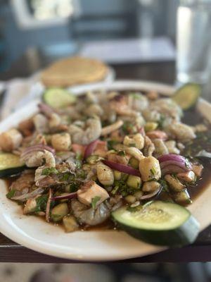 Aguachile Nayarita Shrimp, octopus & scallops submerged in lime juice seasoned with chili peppers, salt. cilantro & slices of onion