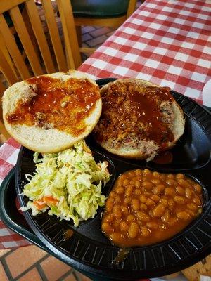 Pork dinner with coleslaw and baked beans.