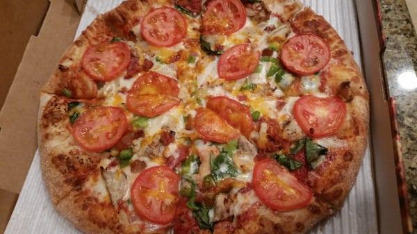 Chicken fresco pizza with green peppers and spinach added.