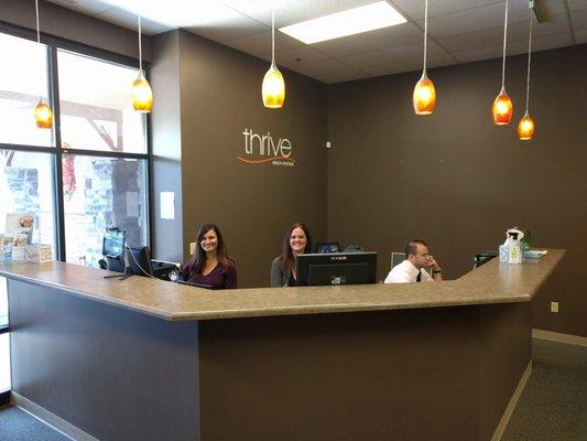 Alysha (Manager, far left), Melissa, and Dr. Joe Sullivan, hanging at the front desk.