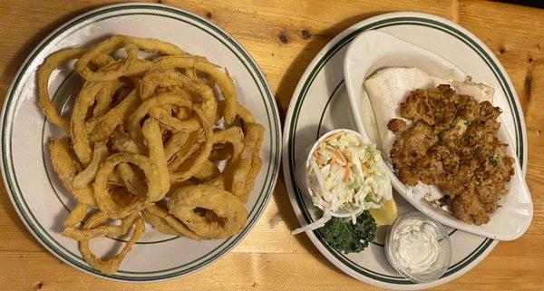 Dinner portion of baked haddock with crab seafood stuffing and onion rings