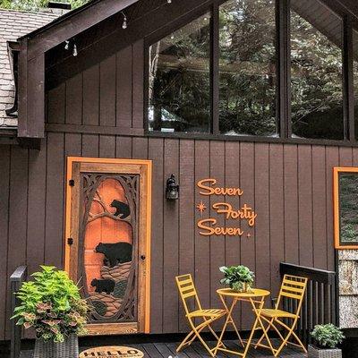 @theweekendernc made a bold & beautiful welcome to their cabin! The bear family screen door looks great in front of this orange paint.