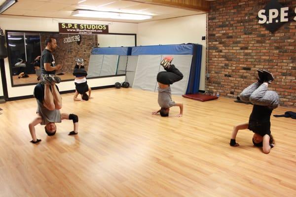 Adult Break dance class
 students learning how to balance on head stands and lift into a elbow freeze.... so cool