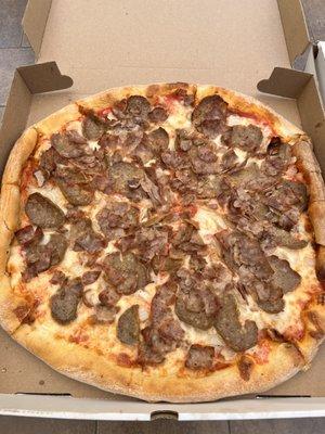 Pizza pie with sausage, meatballs, and onions