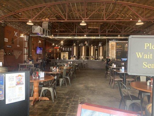 Overview of restaurant seating area with brewery in back.