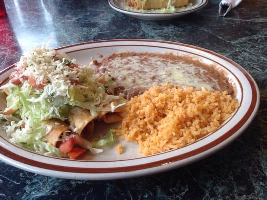 Rolled chicken tacos with guac, beans and rice. $6.99