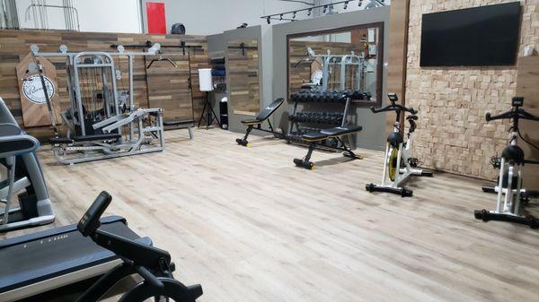 This gym project took a some time since the client wanted to use  vinyl flooring. Wood panels for the wall and barn door.