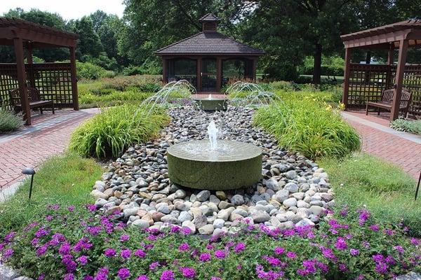 Secured garden with wheel chair and walker friendly trails, meditative fountain, screened in gazebo, and bistro seating.