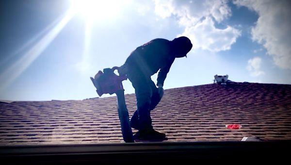 Worker blowing trash out of gutters with a leaf blower