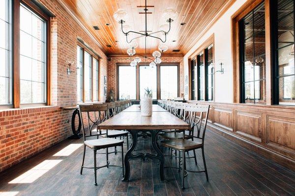 Inside the Elizabeth Room features industrial style tables and chairs, unique lighting and a wet-bar.