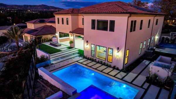 Custom backyard with pool, water wall, basketball court and fire feature