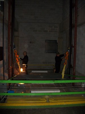 Mechanic hanging a hydraulic elevator before performing a repair.