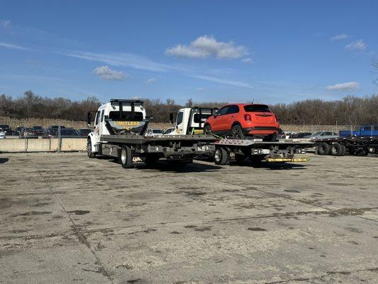 2 of our flatbed tow trucks getting ready to tow 4 cars