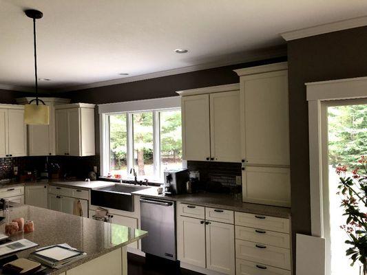 This is a beautiful new kitchen with new cabinets farm sink and crown molding and wall paint.