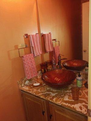 finished powder room. The walls are a metallic copper.