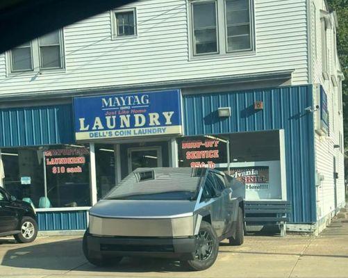 I was told this is the owners's Tesal. How about parking it somewhere else so your customers don't have to carry their laundry so far?