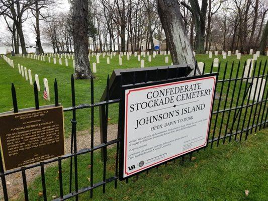 The roadside entrance to the Confederate Stockade Cemetery, as well as the National Historic Landmark sign, which was designated in 1990.