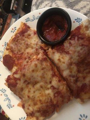 Plate of spicy inedible pizza and marinara sauce.