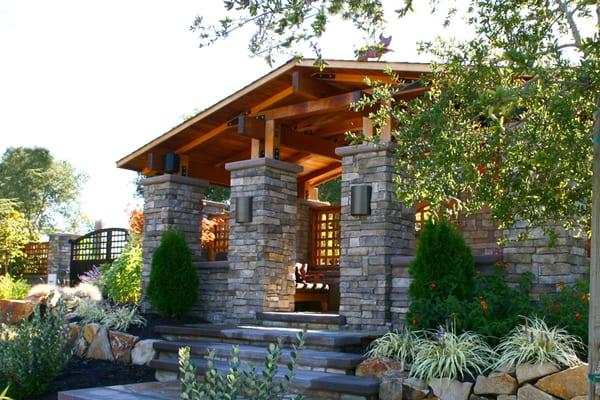 Craftsman style entry structure surrounded by beautiful drought tolerant plants.