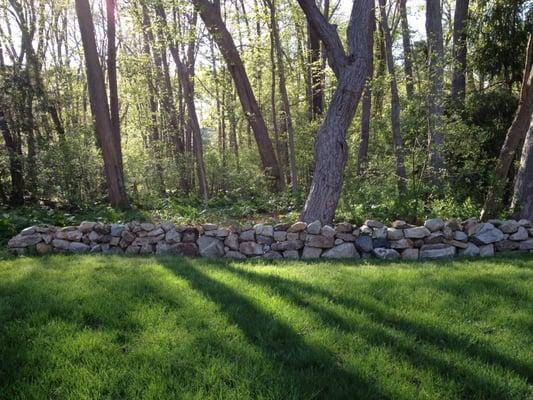 Natural stone wall built by M. E. Bass Landscaping.