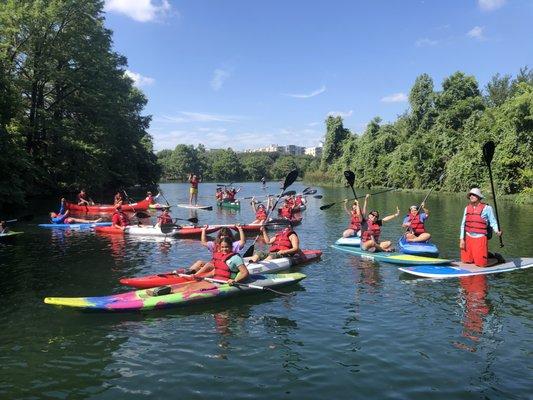 This team of paddlers on the river is celebrating the beautiful weather, water, and memories made together.