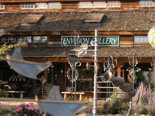 A view Of Envision Gallery through the Kinetic Wind Sculptures by Lyman Whitaker