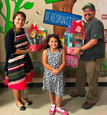 Dana and his grandaughter, pleased as punch to give the School Supply basket they won to her teacher.