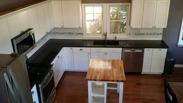 This Kitchen turned out beautiful! With concrete counter tops, a built in bench for seating, and a custom roll-away island th...