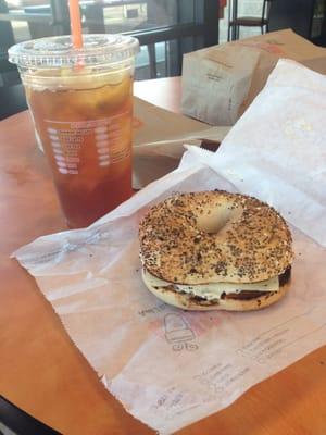 Iced tea and chicken salad on an everything bagel with cheddar cheese.