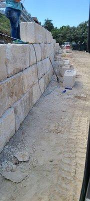 Installing large stone wall.