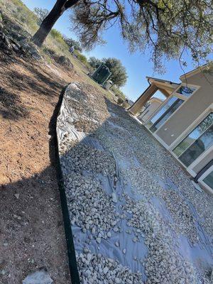 Fabric installed under river rock to prevent weeds from growing in