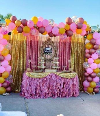 Sequin backdrop with balloon garland, 2 balloon columns, and decorated tables with cake stands