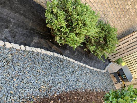 Cleaned out beds of mulch, laid landscaping fabric, about to install small mountain bed rock.