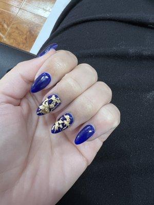 Full acrylic nail set featuring a cobalt blue polish with gold foil on the middle and ring finger