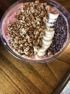 PB&J smoothie bowl with added granola, sliced banana, and cacao nibs.